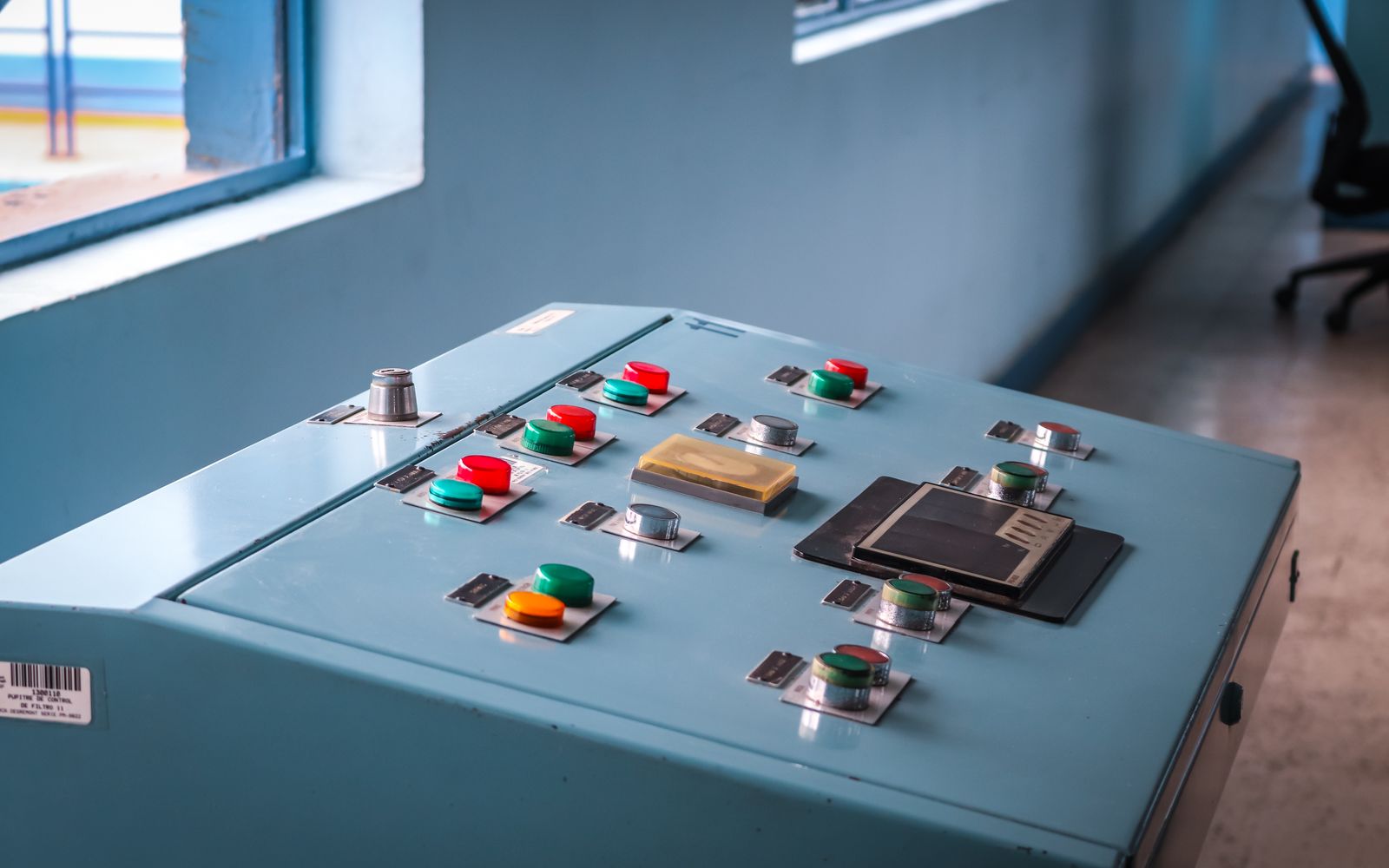 Close-up of an industrial control panel with colorful buttons in a factory setting.
