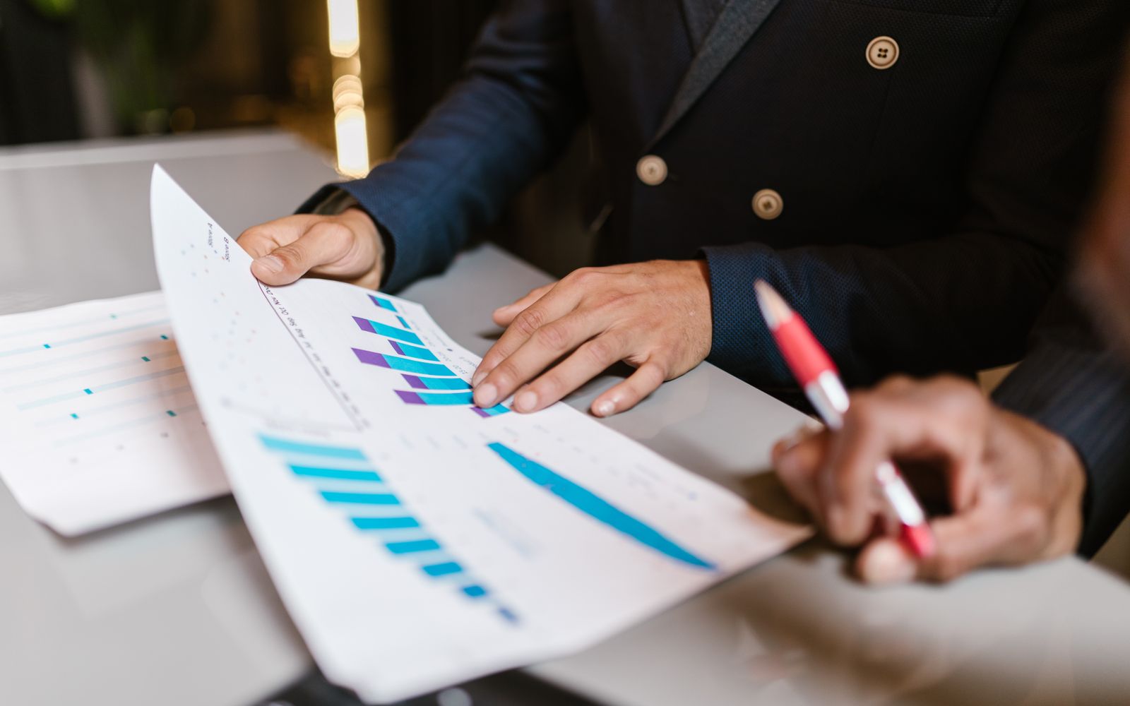 Close-up of professionals reviewing financial graphs at a business meeting.