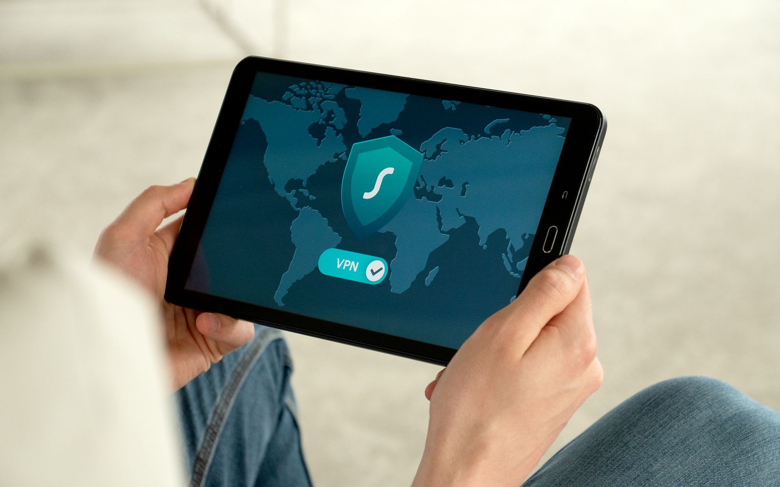 Person holding tablet with VPN connection screen for secure internet browsing.