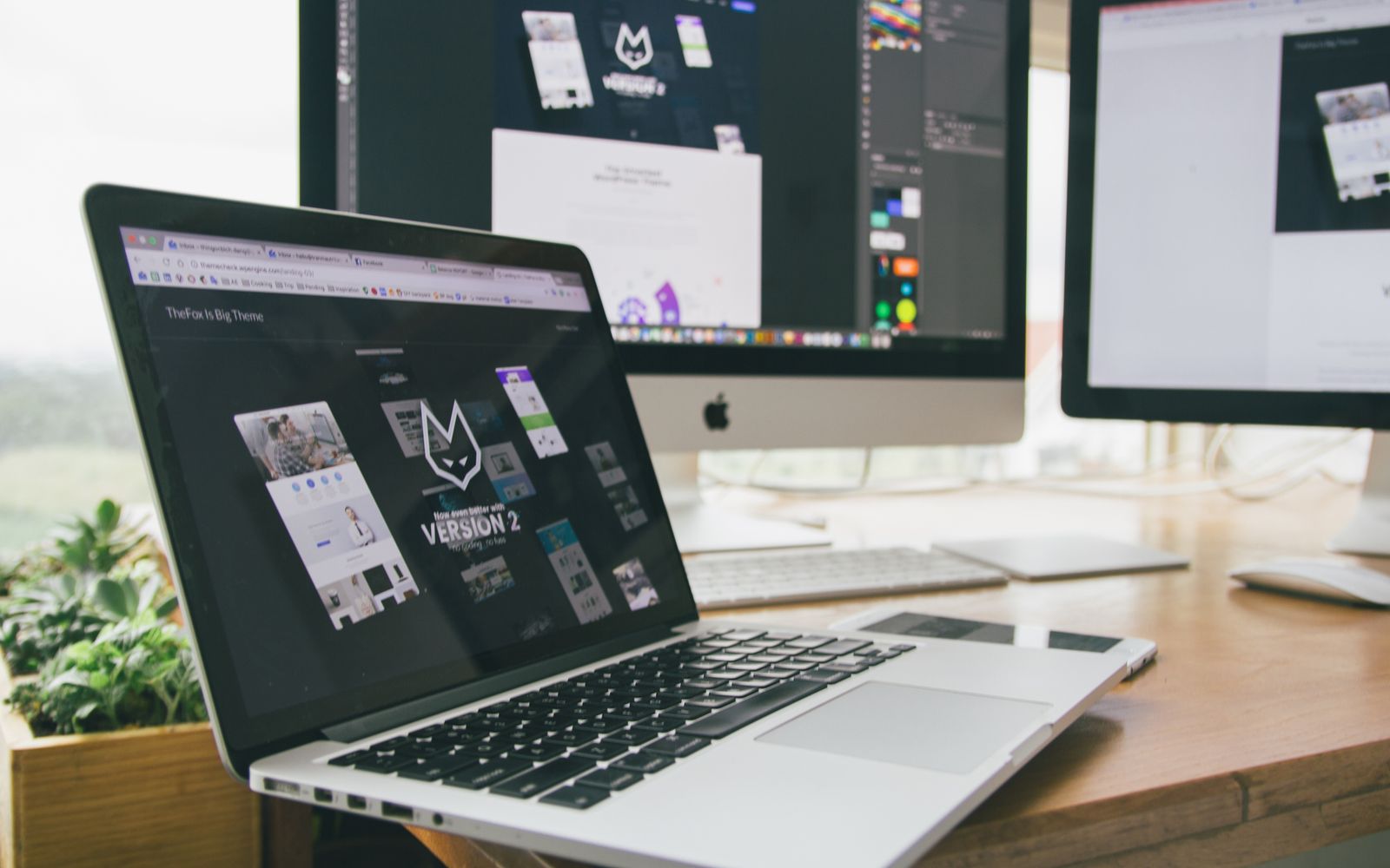 A stylish workspace featuring a laptop and monitors displaying design software.
