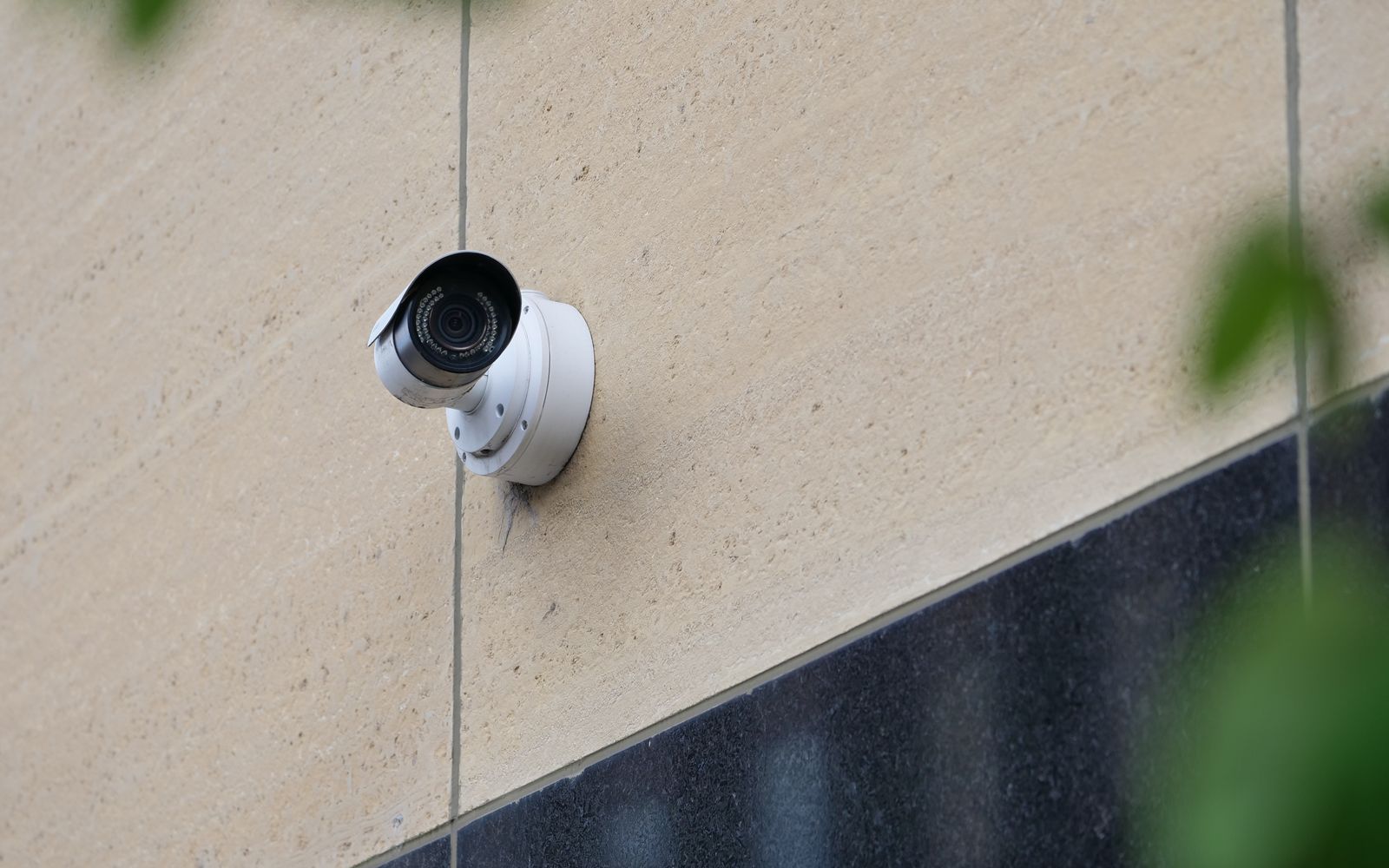 Modern CCTV camera mounted on a city building wall for security monitoring.