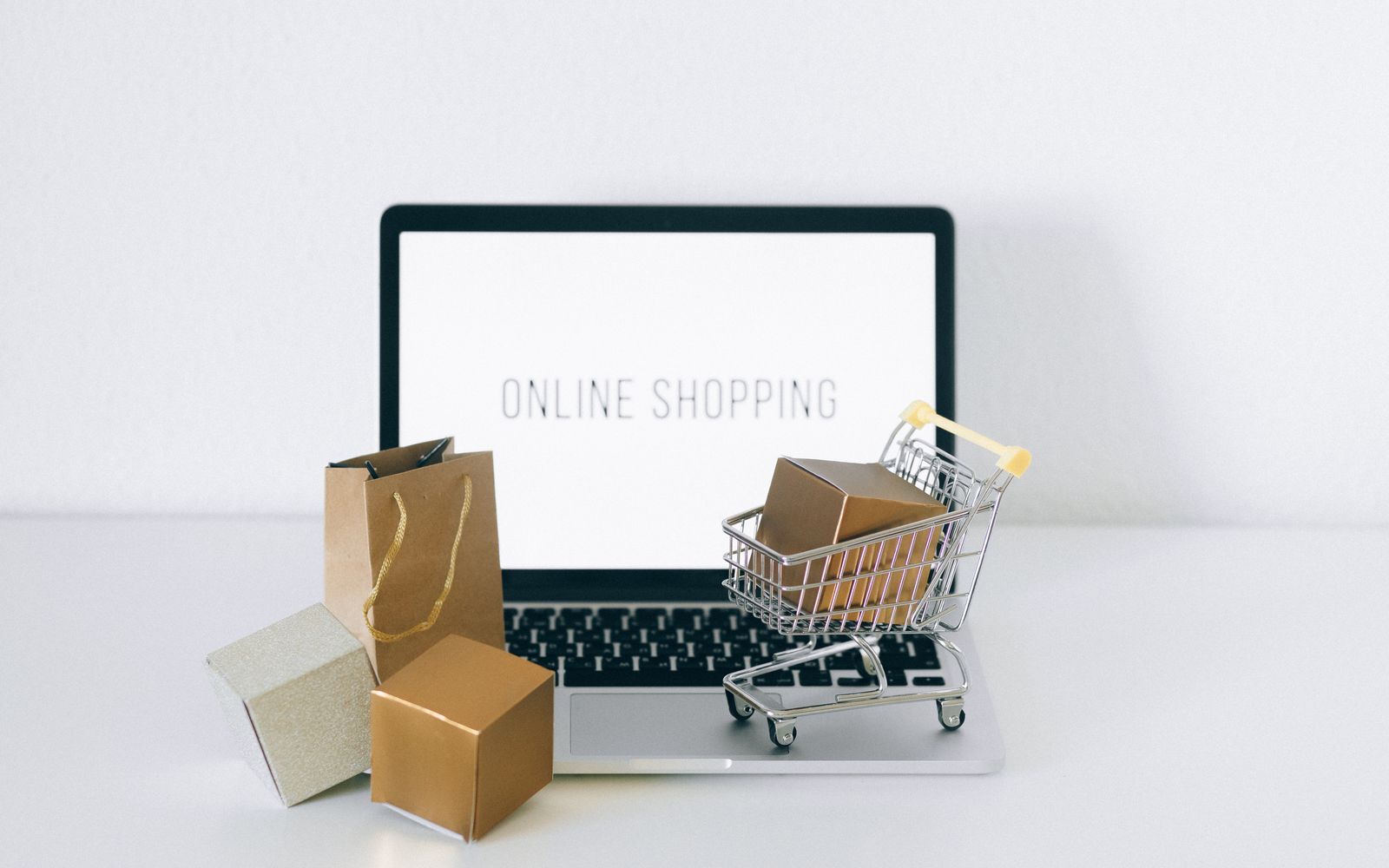 Laptop displaying online shopping with boxes and cart, representing ecommerce.