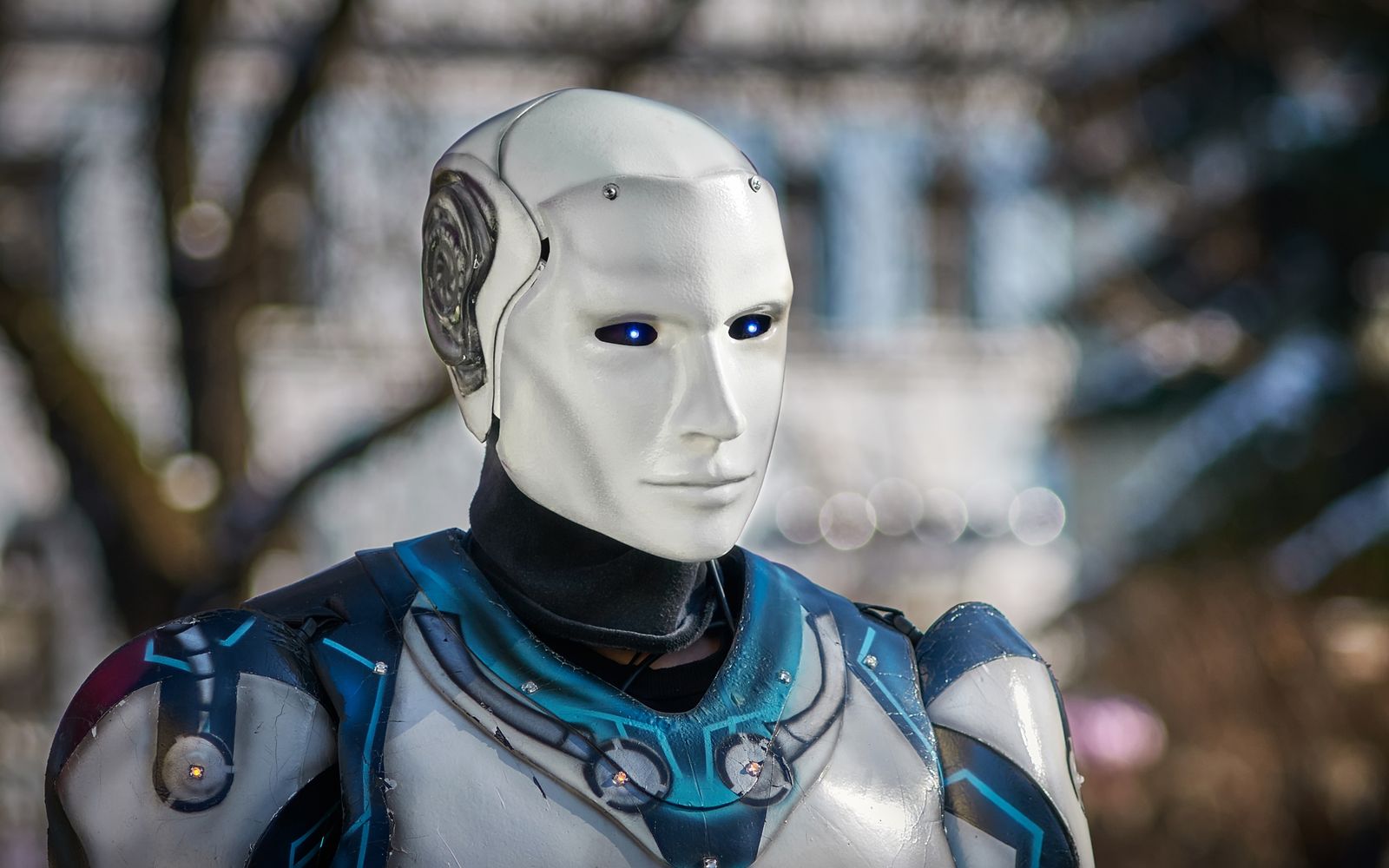 Close-up of a futuristic humanoid robot with metallic armor and blue LED eyes.