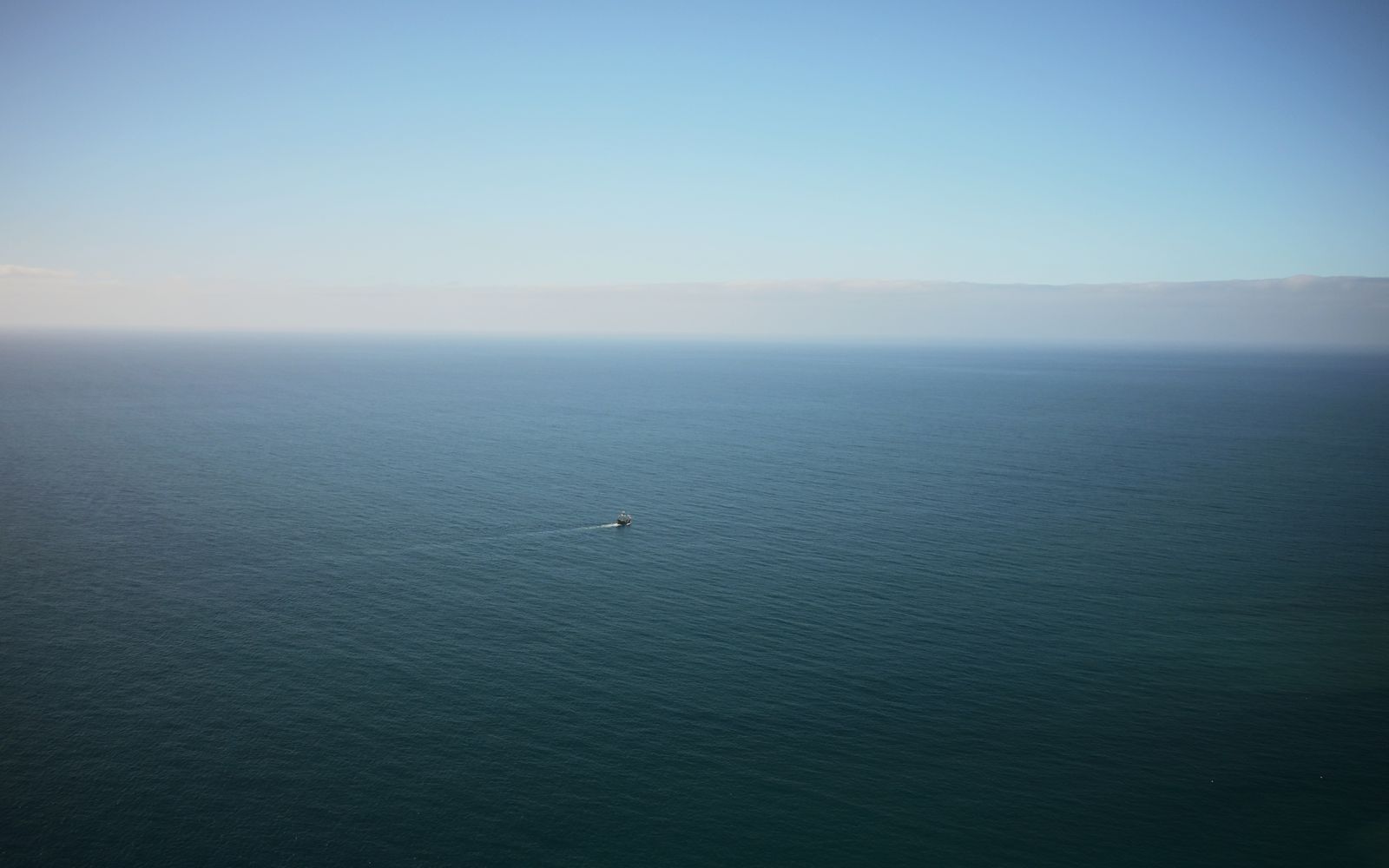 Peaceful ocean view with a lone boat, captured from Madeira, Portugal.