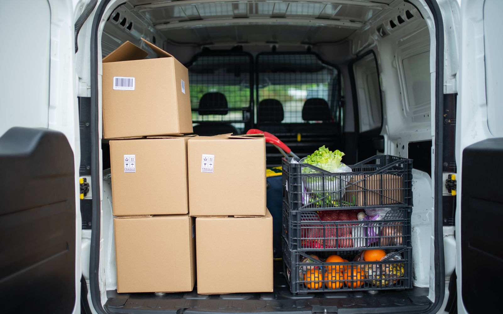 Packed delivery van with boxes and fresh produce crates for efficient logistics.